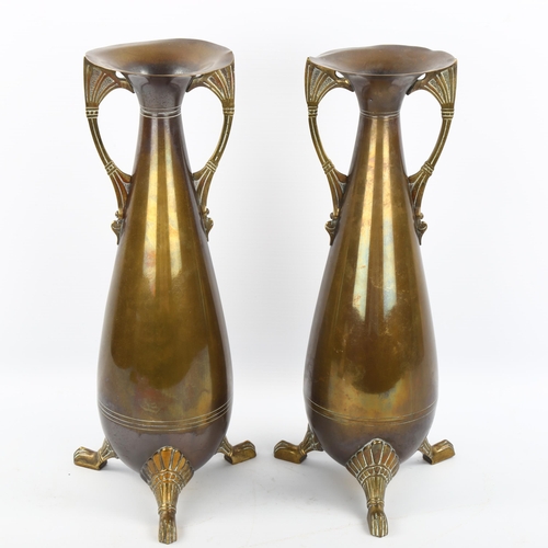 1128 - A pair of Dutch brass vases on cast feet, height 33cm