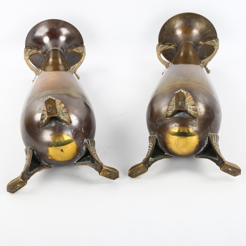 1128 - A pair of Dutch brass vases on cast feet, height 33cm