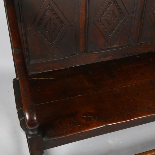 1133 - An 18th century oak settle of small size, with lozenge carved 5-panel back and bobbin turned support... 