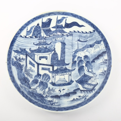 1142 - A Chinese blue and white porcelain charger, with hand painted palace fortifications, diameter 37cm