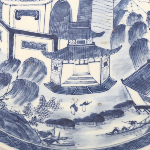 1142 - A Chinese blue and white porcelain charger, with hand painted palace fortifications, diameter 37cm