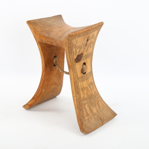 1154 - An African wood neck rest with engraved sides, height 19cm