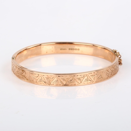 369 - An early 20th century 9ct rose gold hinged bangle, with engraved leaf decoration, maker's marks S Br... 