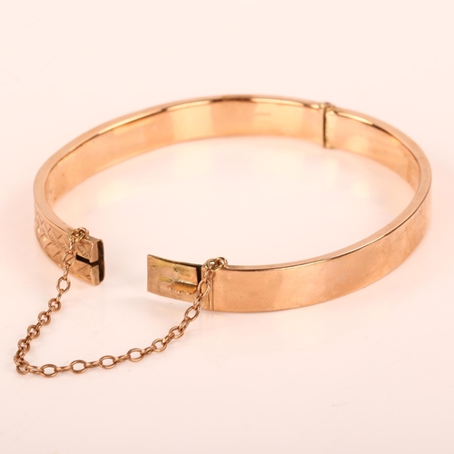 369 - An early 20th century 9ct rose gold hinged bangle, with engraved leaf decoration, maker's marks S Br... 