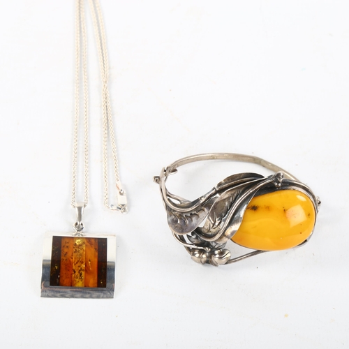 487 - An Austrian silver and butterscotch amber floral bracelet, and a silver and specimen amber pendant n... 