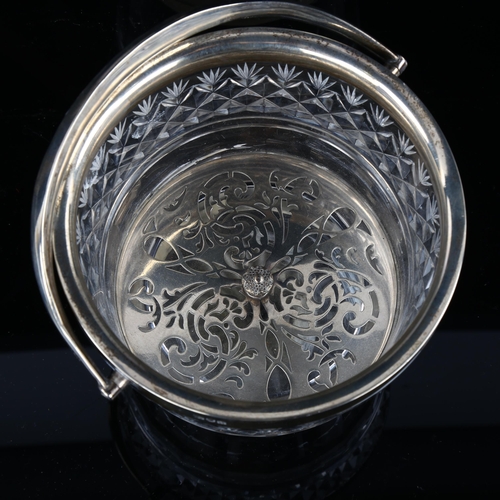 540 - A George V silver-mounted glass ice bucket, with swing handle and pierced liner, armorial crest on h... 