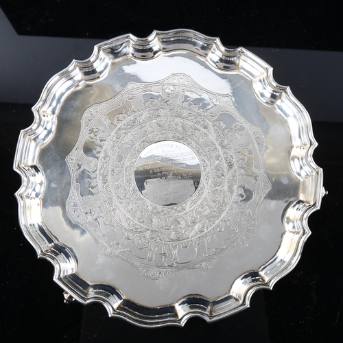 544 - A George V silver salver, circular form with scalloped rim and Indian inspired engraved animal decor... 