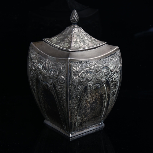 579 - A Victorian silver tea caddy, shaped square form with relief embossed floral decoration and flame fi... 