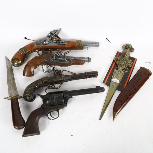 527 - A group of reproduction replica pistols, a knife in wooden scabbard etc