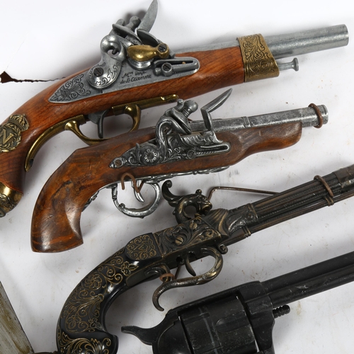 527 - A group of reproduction replica pistols, a knife in wooden scabbard etc