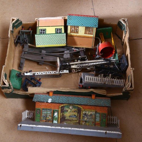 523 - Hornby tin train station and signal boxes, including water tank and various accessories