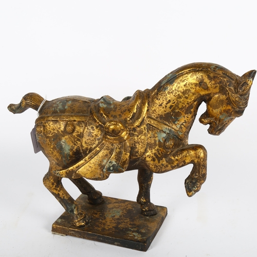 593 - A gilded cast-metal Tang style horse, height 27cm