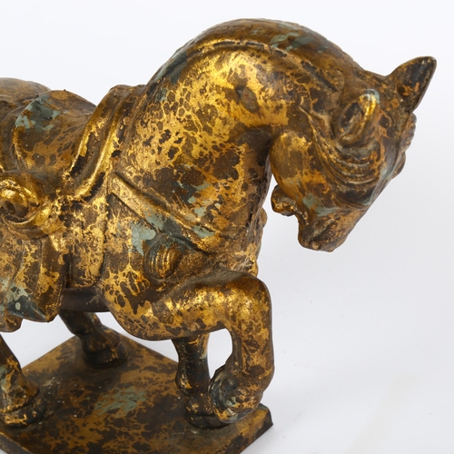 593 - A gilded cast-metal Tang style horse, height 27cm