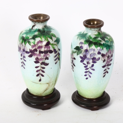 140 - A pair of small Chinese cloisonne vases, with character marks to the base, height 9cm, on turned woo... 