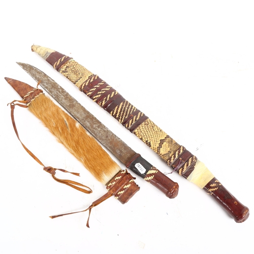 208 - 2 African short swords, with woven leather and hide scabbards, longest 67cm