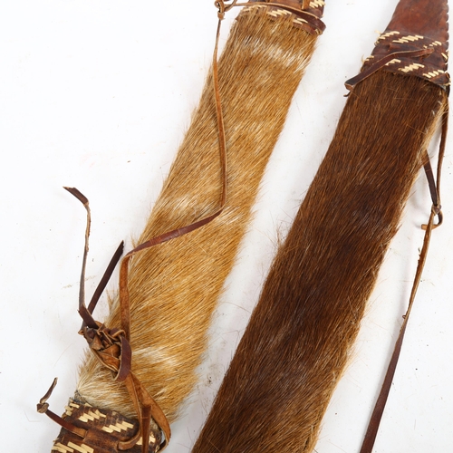 210 - 2 African short swords, with leather and hide-covered scabbards, length 52cm