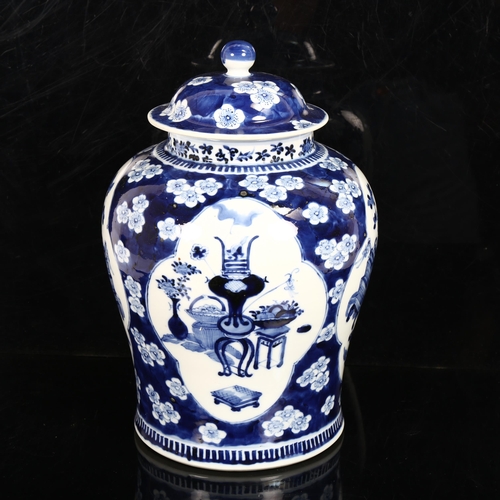 216 - A large Chinese blue and white ginger jar and cover, with genre panels on prunus decorated ground, h... 