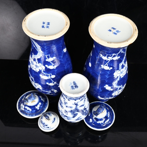 227 - A pair of Chinese blue and white prunus decorated baluster vase and covers, with 4 character mark to... 