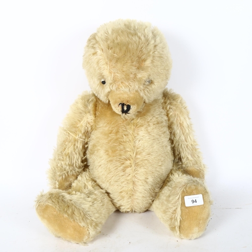 94 - A large straw-filled teddy bear, height 65cm