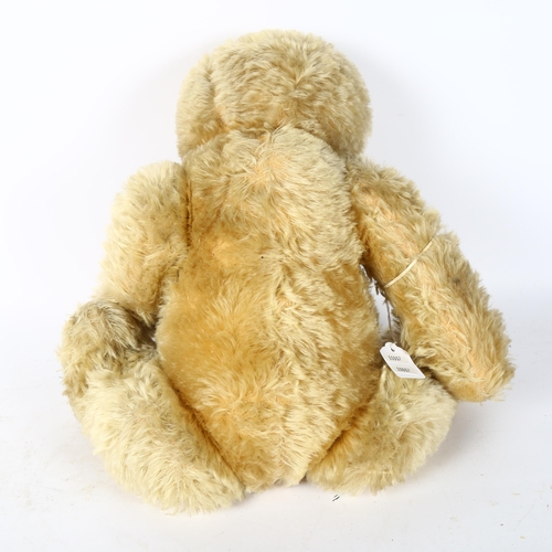 94 - A large straw-filled teddy bear, height 65cm