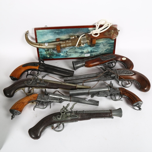 352 - Reproduction pistols, an Eastern knife with embossed metal scabbard and wall plaque