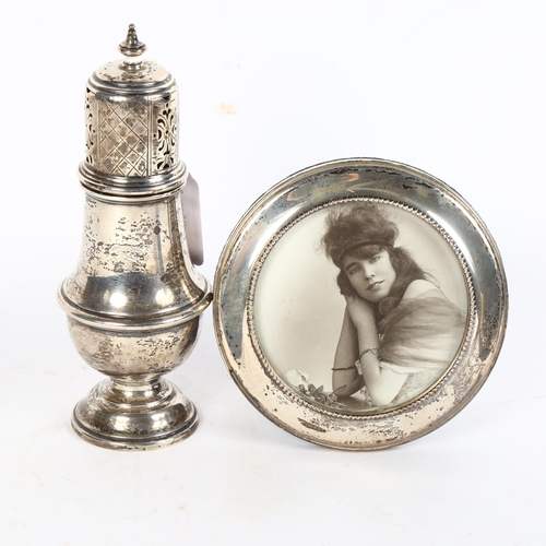 1004 - A George V silver sugar caster, Birmingham 1915, and a circular silver-fronted photo frame (2)