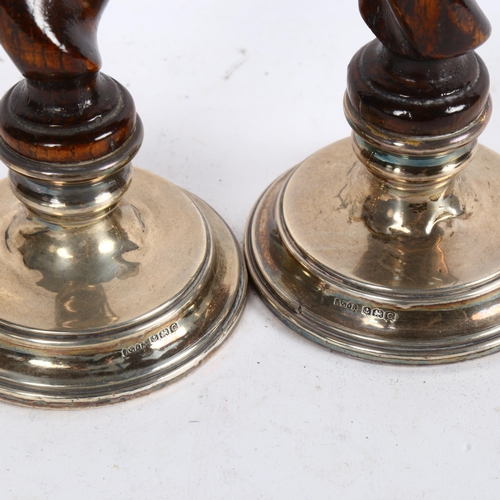 1016 - A pair of George V silver-mounted candlesticks, with oak barley twist columns, height 17cm, hallmark... 