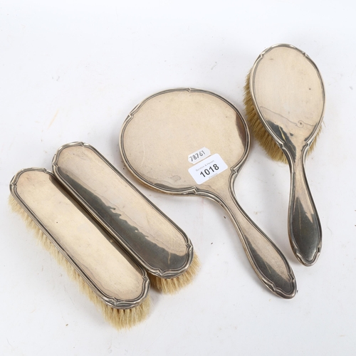 1018 - A 4-piece silver-backed dressing table brush and mirror set