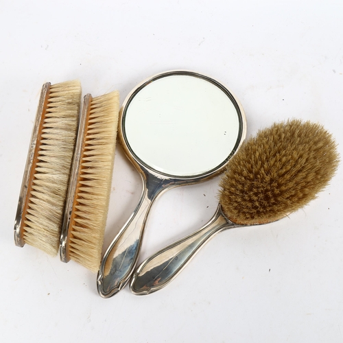 1018 - A 4-piece silver-backed dressing table brush and mirror set