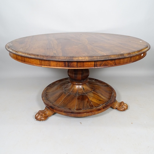 2528 - A 19th century rosewood tilt-top table, with circular base and lion paw feet, 130cm x 71cm