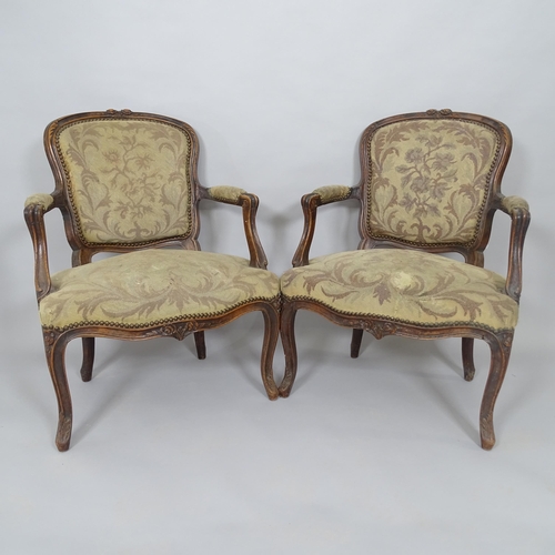 2577 - A pair of French walnut and upholstered open armchairs