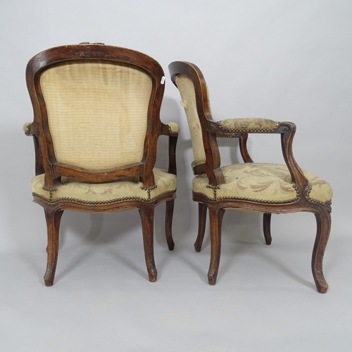 2577 - A pair of French walnut and upholstered open armchairs