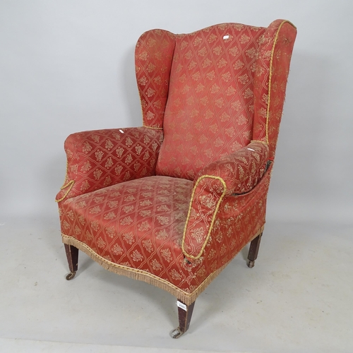 2579 - An early 20th century mahogany and upholstered wingback fireside armchair (for reupholstery)