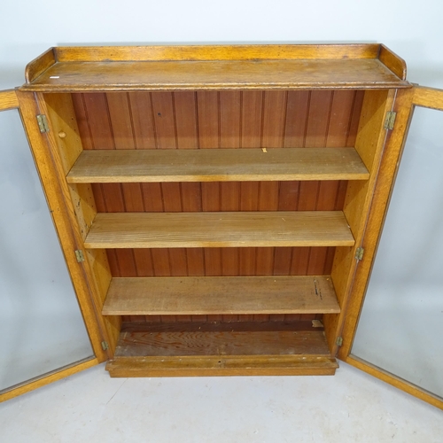 2594 - A 1930s oak 2-door bookcase, with 3 adjustable shelves, 105cm x 135cm x 28cm