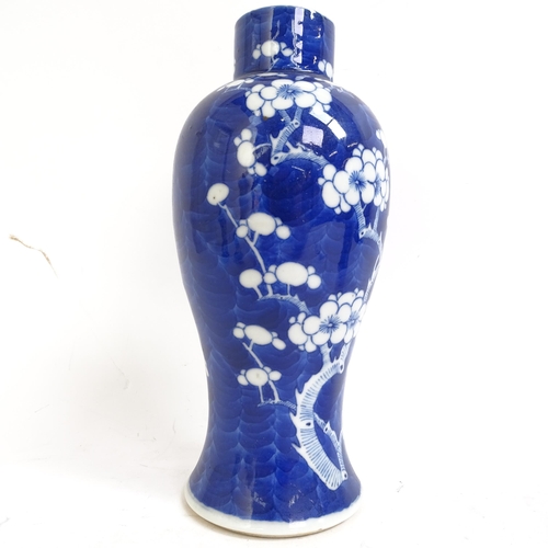 227 - A pair of Chinese blue and white prunus decorated baluster vase and covers, with 4 character mark to... 