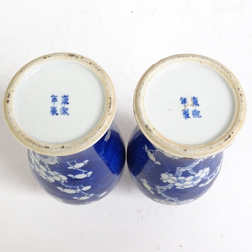 227 - A pair of Chinese blue and white prunus decorated baluster vase and covers, with 4 character mark to... 