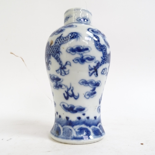 227 - A pair of Chinese blue and white prunus decorated baluster vase and covers, with 4 character mark to... 