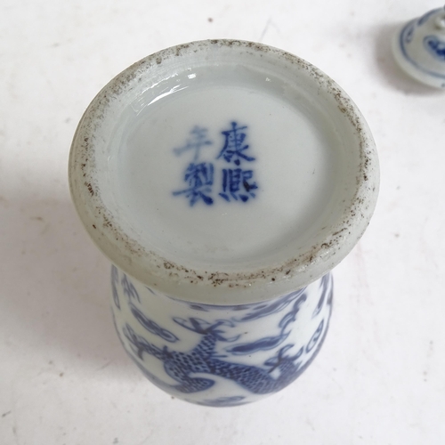 227 - A pair of Chinese blue and white prunus decorated baluster vase and covers, with 4 character mark to... 