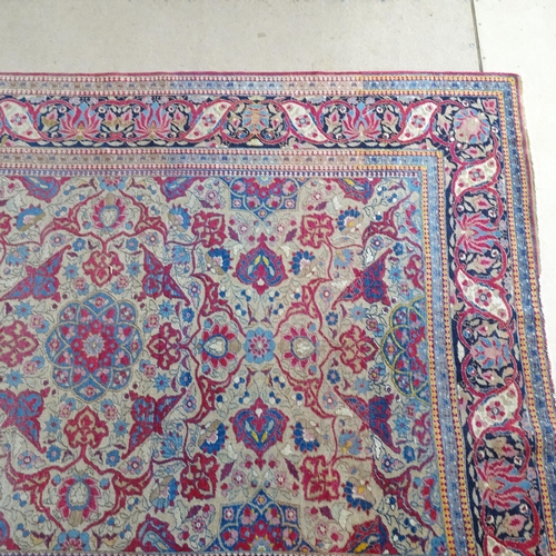 2426 - An Antique red ground Persian Isfahan rug, with repeating border and floral decorated square lozenge... 