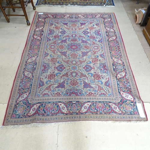 2426 - An Antique red ground Persian Isfahan rug, with repeating border and floral decorated square lozenge... 