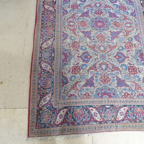 2426 - An Antique red ground Persian Isfahan rug, with repeating border and floral decorated square lozenge... 