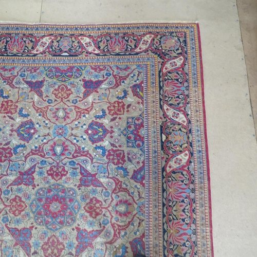 2426 - An Antique red ground Persian Isfahan rug, with repeating border and floral decorated square lozenge... 