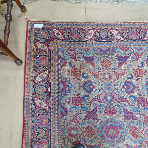 2426 - An Antique red ground Persian Isfahan rug, with repeating border and floral decorated square lozenge... 