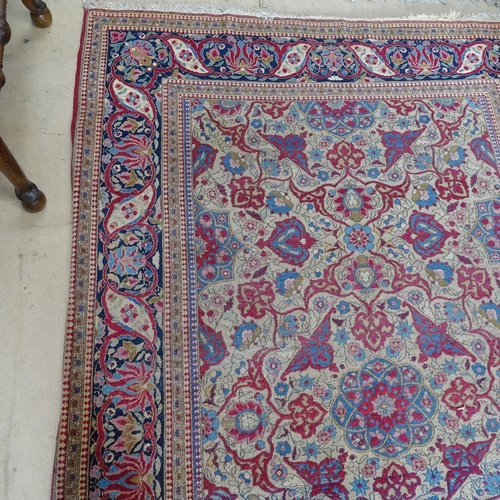 2426 - An Antique red ground Persian Isfahan rug, with repeating border and floral decorated square lozenge... 