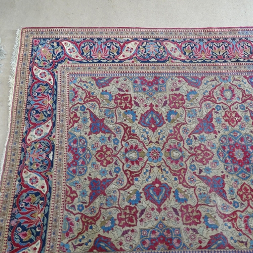 2426 - An Antique red ground Persian Isfahan rug, with repeating border and floral decorated square lozenge... 