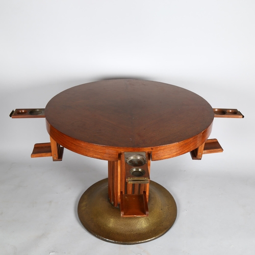 1585 - An Austrian Secessionist games table, circular top with pull out and drop down drinks holders, raise... 