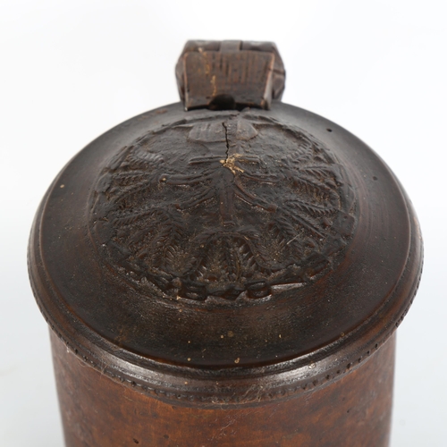 1001 - An 18th century Scandinavian birch peg tankard, with carved hinged lid, resting on 3 carved feet, he... 