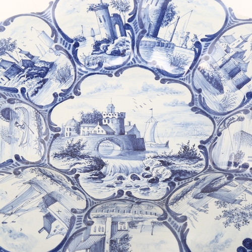 1021 - A 19th century Delft pottery cushion-shaped dish with painted panels, diameter 33cm