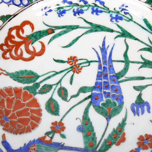 1041 - A Middle Eastern Iznik polychrome glazed plate with exotic bird decoration, diameter 31cm