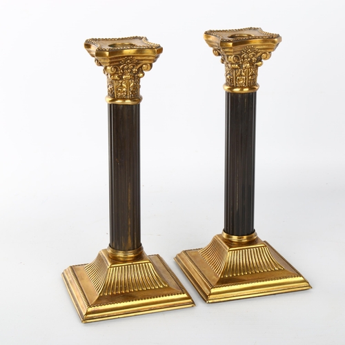 1042 - A pair of French patinated brass Corinthian column candlesticks, late 19th/early 20th century, heigh... 